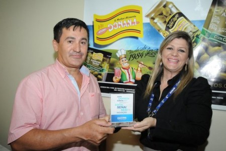 Daniely Sotolani, do Instituto Senai, entrega troféu ao proprietário da Donana Alimentos, Antônio Lucena